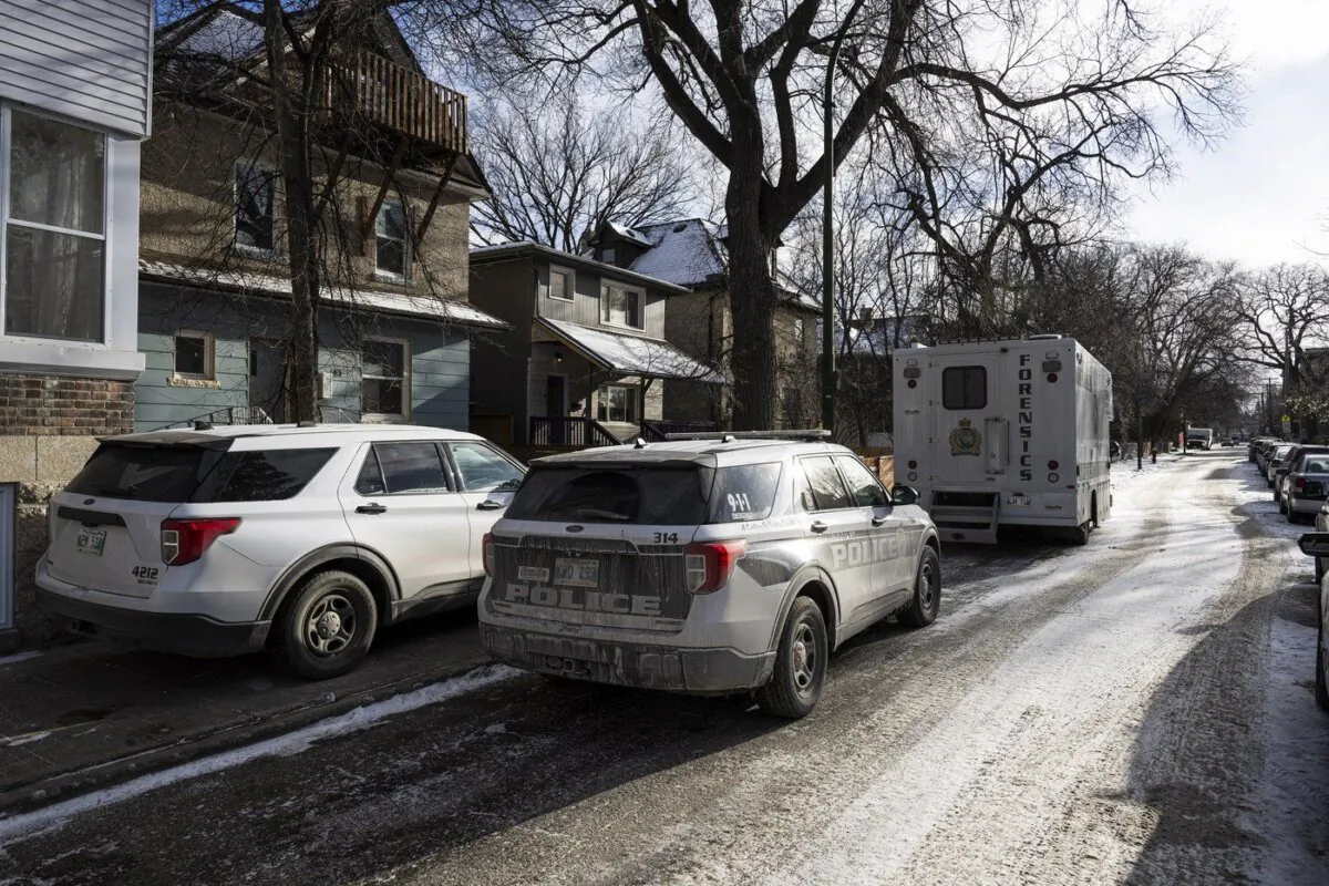 Police vehicles are shown outside the scene of a shooting at a home in Winnipeg on Nov. 27, 2023. (The Canadian Press/Aaron Vincent Elkaim)
