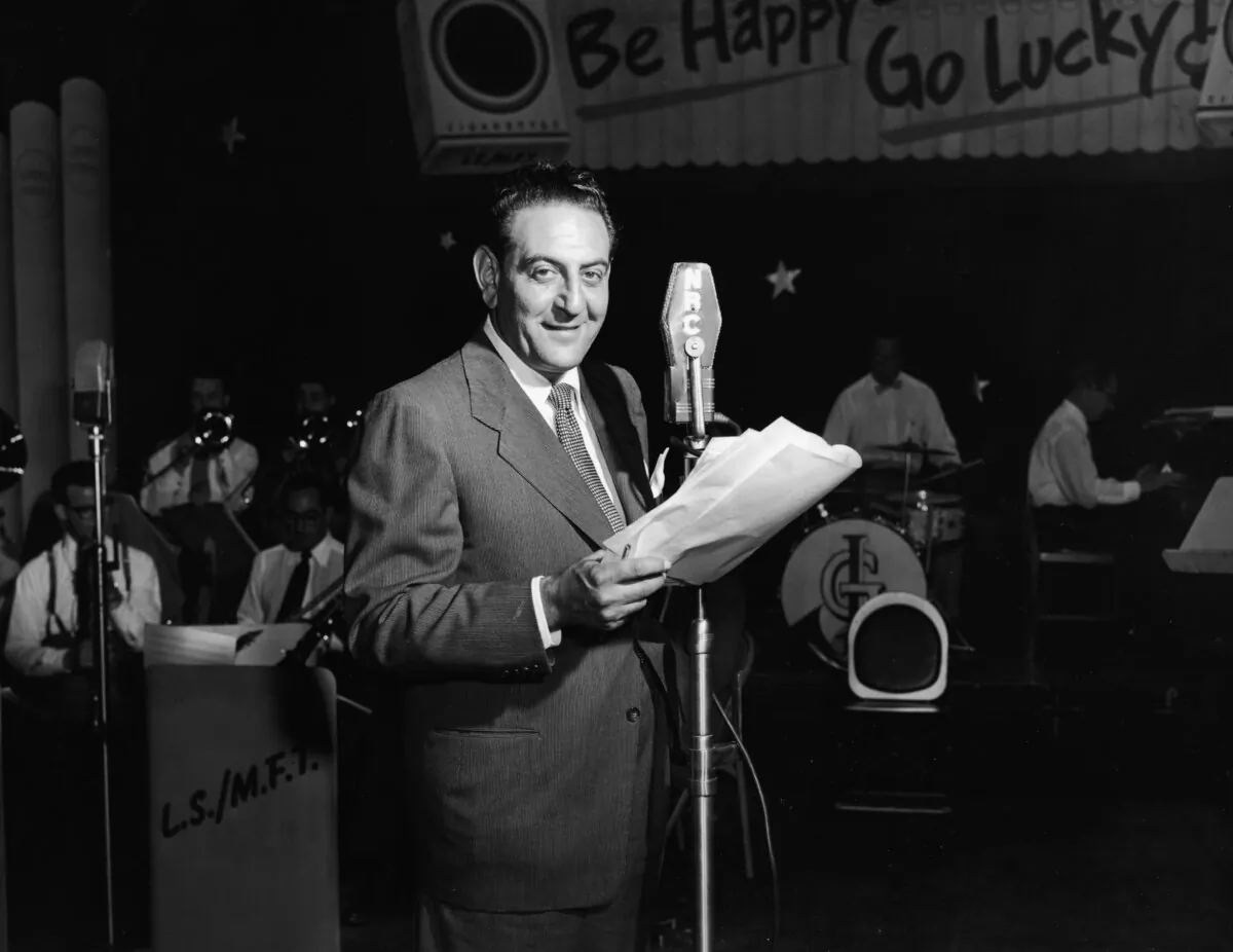 Canadian-American bandleader Guy Lombardo stands at an NBC microphone, circa 1950. (Phil Burchman/Getty Images)