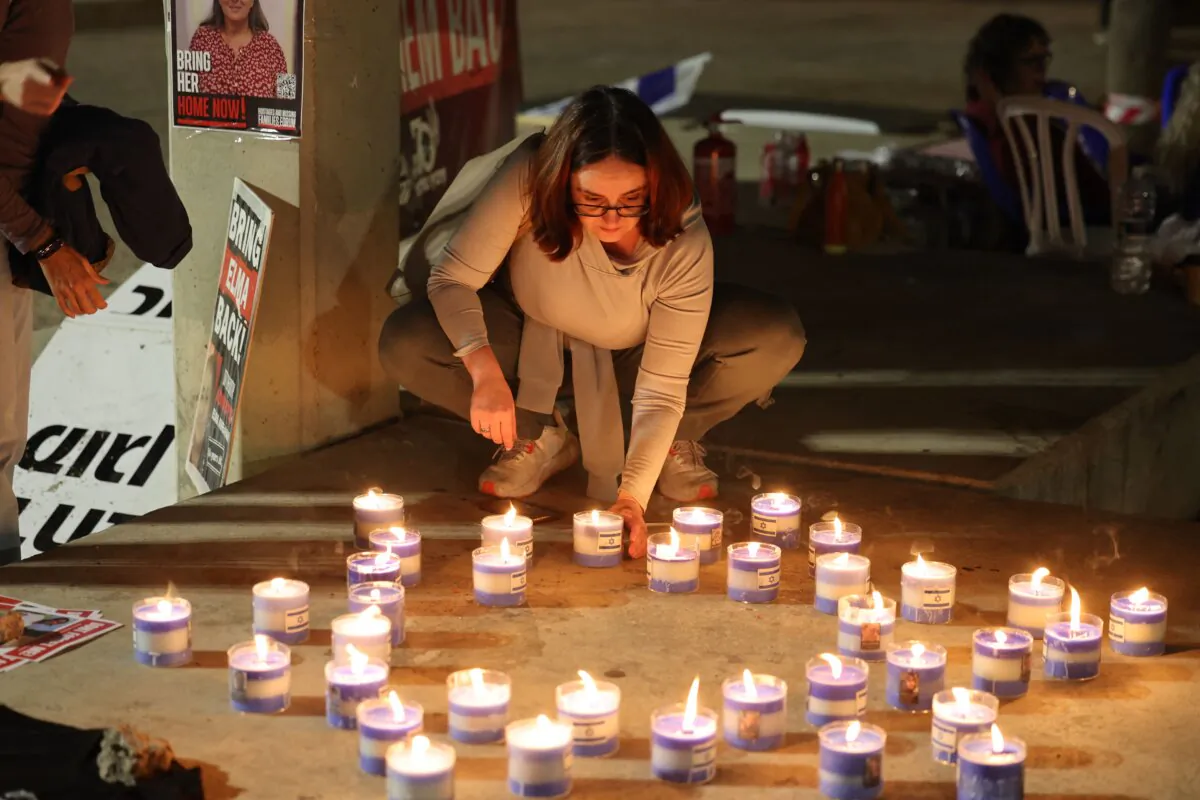 A woman lights candles during a gathering in Tel Aviv, Israel, on Nov. 21, 2023, demanding the release of Israelis held hostage in Gaza since the Oct. 7 attack by Hamas. (Ahmad Gharabli/AFP via Getty Images)