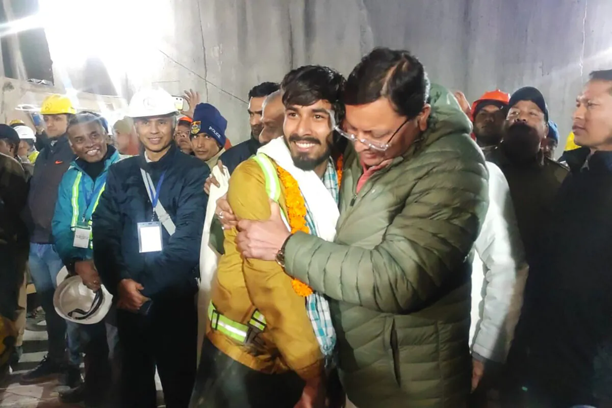 Pushkar Singh Dhami (R), chief minister of the state of Uttarakhand, greets a worker rescued from the site of an under-construction road tunnel that collapsed in Silkyara in the northern Indian state of Uttarakhand, India, on Nov. 28, 2023. (Uttarakhand State Department of Information and Public Relations via AP)
