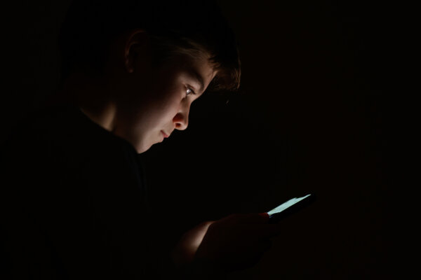 A teenage child looks at the screen of a mobile phone on January 17, 2023 in London, England. (Leon Neal/Getty Images)