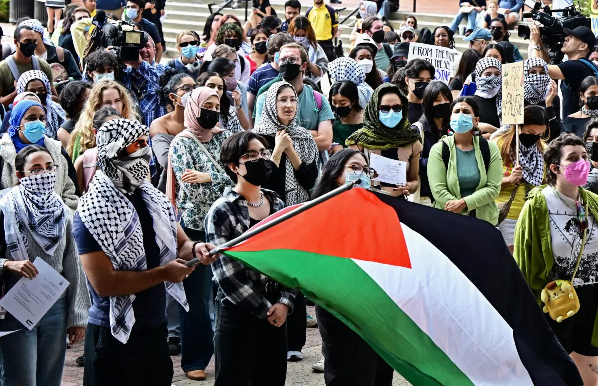 A person holds a Palestinian flag as students participate in a "Walkout to fight Genocide and Free Palestine" at Bruin Plaza at University of California–Los Angeles on Oct. 25, 2023. (Frederic J. Brown/AFP via Getty Images)
