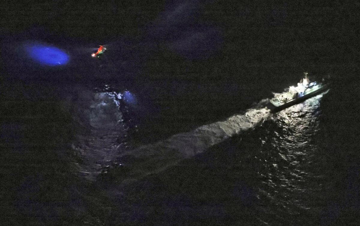 A Japan's coast guard vessel and a helicopter conduct search and rescue operation around the site where a U.S. military Osprey aircraft was believed to crash in the sea off Yakushima Island, Kagoshima prefecture, southern Japan on Nov. 29, 2023. (Kyodo News via AP)