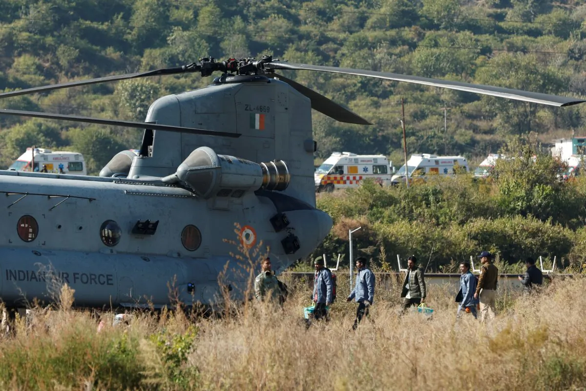 Workers, who were rescued from a tunnel which collapsed in Uttarkashi, walk to board an Indian Air Force's Chinook helicopter to be airlifted to AIIMS Rishikesh hospital, in Chinyalisaur, in the northern state of Uttarakhand, India, on Nov. 29, 2023. (Francis Mascarenhas/Reuters)