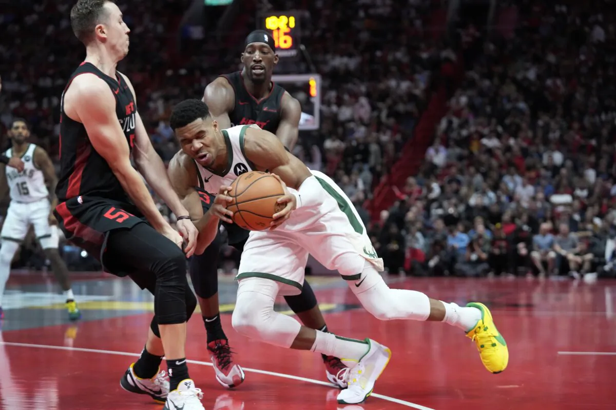 Milwaukee Bucks forward Giannis Antetokounmpo (C) collides with Miami Heat forward Duncan Robinson (55) as he drives past Robinson and center Bam Adebayo, rear, during the second half of an NBA basketball game in Miami on Nov. 28, 2023. (Wilfredo Lee/AP Photo)