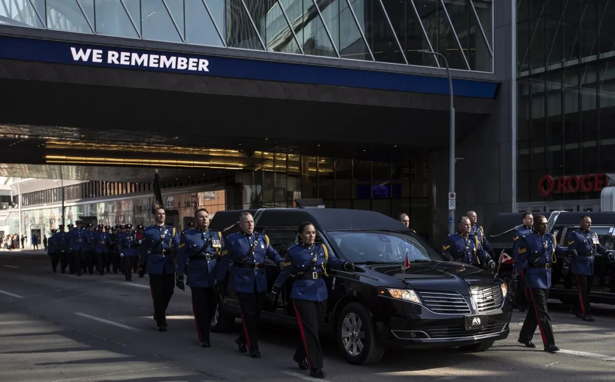 Police march alongside hearses during the procession for Edmonton Police Service constables Travis Jordan and Brett Ryan in Edmonton, on Mar. 27, 2023. (The Canadian Press/Jason Franson)
