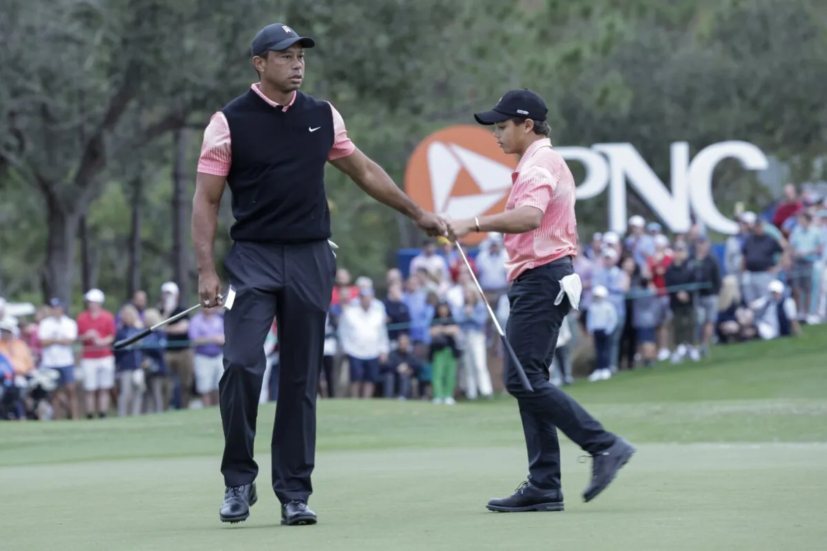 Tiger Woods (L) congratulates his son Charlie Woods after finishing the 18th hole during the first round of the PNC Championship golf tournament in Orlando, Fla., on Dec. 17, 2022. (Kevin Kolczynski/AP Photo)