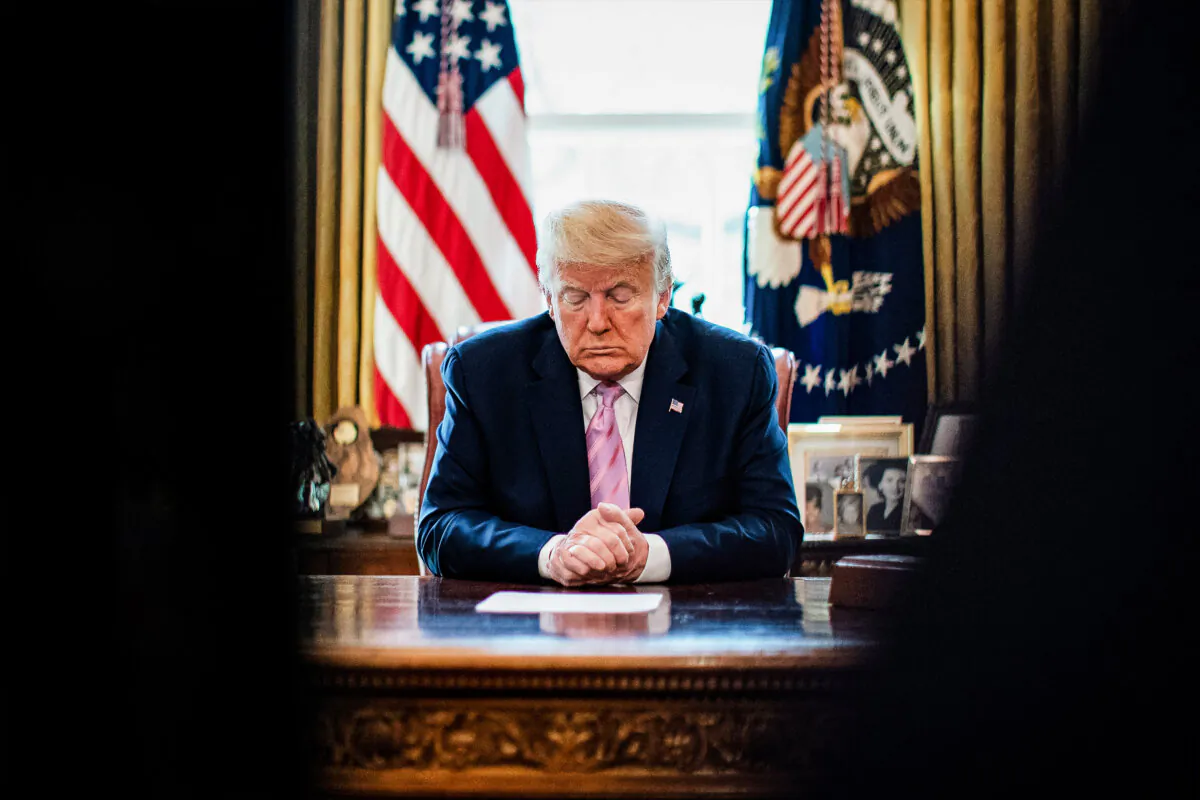 President Donald Trump bows his head during an Easter blessing by Bishop Harry Jackson in the Oval Office on April 10, 2020. (Al Drago - Pool/Getty Images)