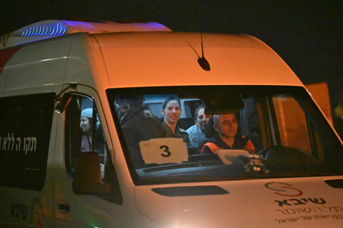 A transit bus takes hostages released earlier by Hamas from the helipad to the buildings at Sheba Medical Center on the sixth day of the temporary truce after Hamas blamed ‘technical issues’ on the delay as family and friends wait nearby in Ramat Gan, Israel, in the early morning hours of Nov. 30, 2023. (Alexi J. Rosenfeld/Getty Images)