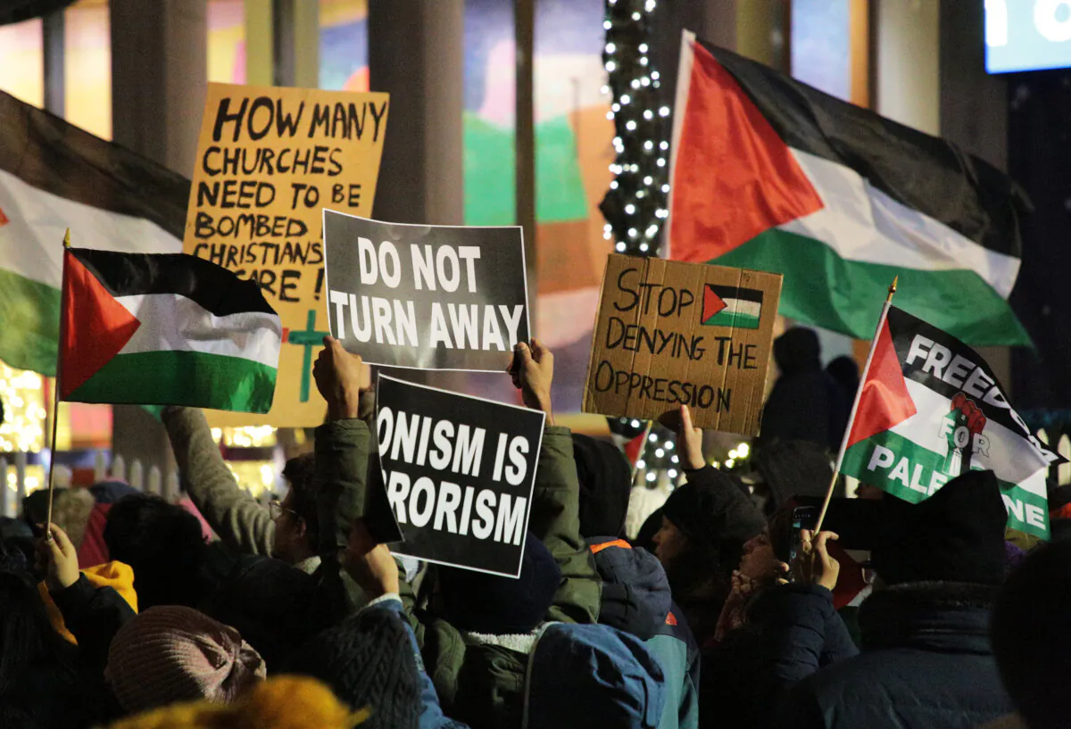 Pro-Palestinian protesters held various signs aloft during their demonstration outside the Fox News building on 6th Ave in Midtown Manhattan on Nov. 29, 2023. (Richard Moore/The Epoch Times)
