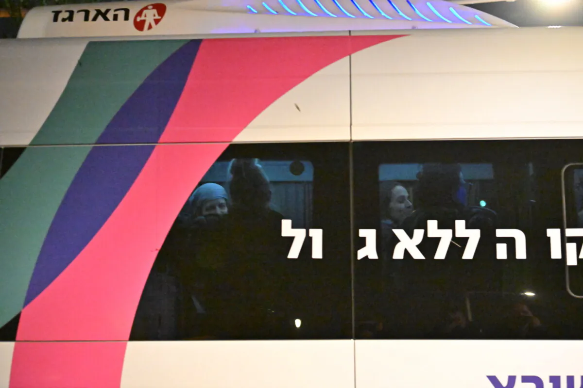 A transit bus takes hostages released earlier by Hamas from the helipad to the buildings at Sheba Medical Centre on the sixth day of the temporary truce after Hamas blamed "technical issues" on the delay as family and friends wait nearby in the early morning hours in Ramat Gan, Israel, of Nov. 30, 2023. (Alexi J. Rosenfeld/Getty Images)