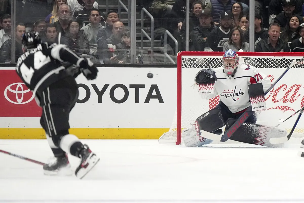 Los Angeles Kings defenseman Mikey Anderson (L) shoots the puck as Washington Capitals goaltender Charlie Lindgren gets ready to deflect it during the first period of an NHL hockey game in Los Angeles on Nov. 29, 2023. (Mark J. Terrill/AP Photo)