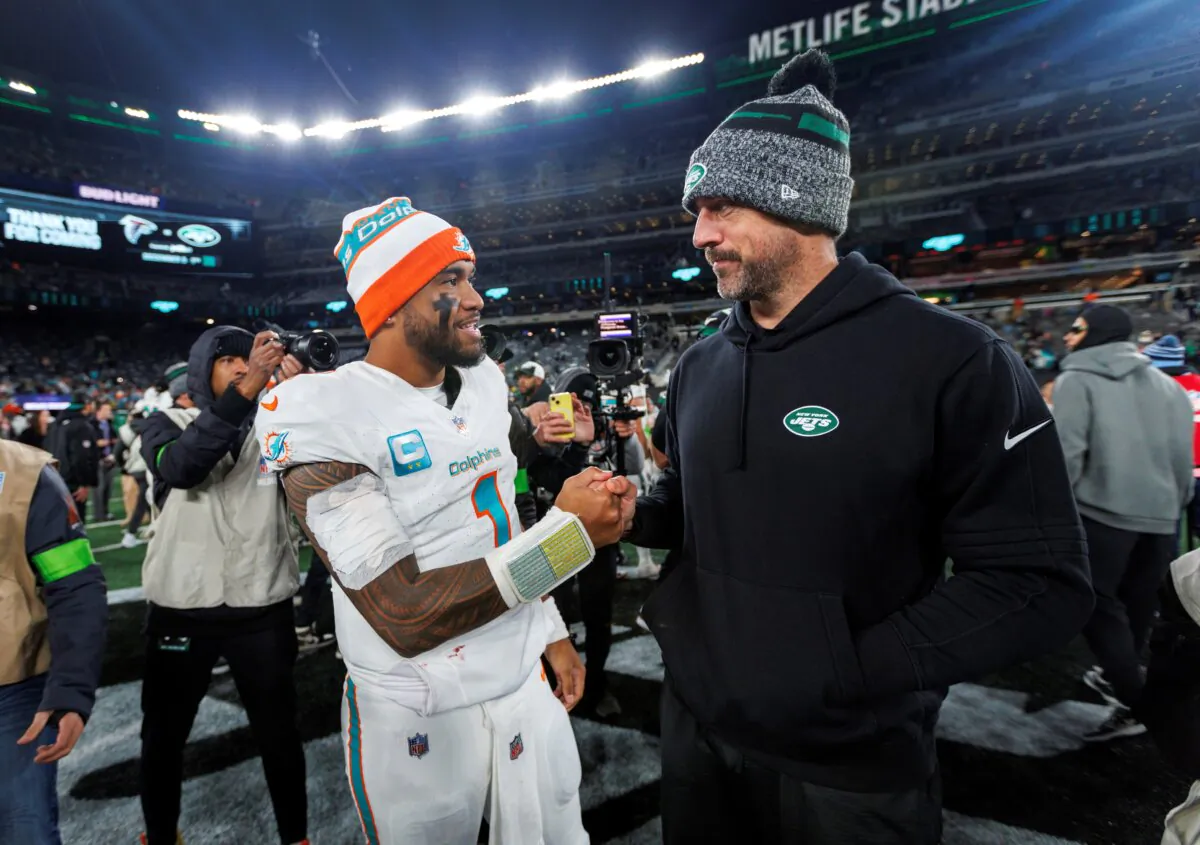 Miami Dolphins quarterback Tua Tagovailoa (1) interacts with New York Jets quarterback Aaron Rodgers (8) after the team's win over the New York Jets during an NFL football game in East Rutherford, N.J., on Nov. 24, 2023. (David Santiago/Miami Herald via AP)