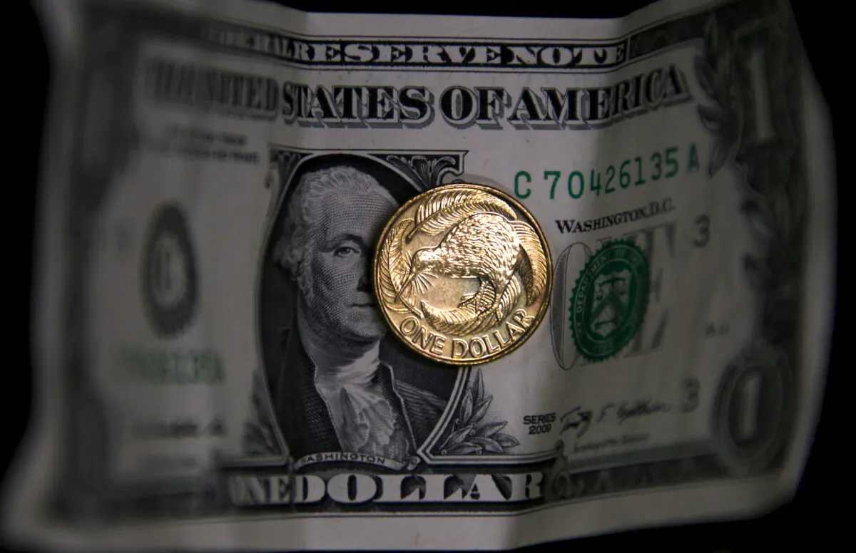 A New Zealand dollar coin sits atop a United States one dollar bill in this photo illustration taken on March 11, 2016. (David Gray/Reuters)