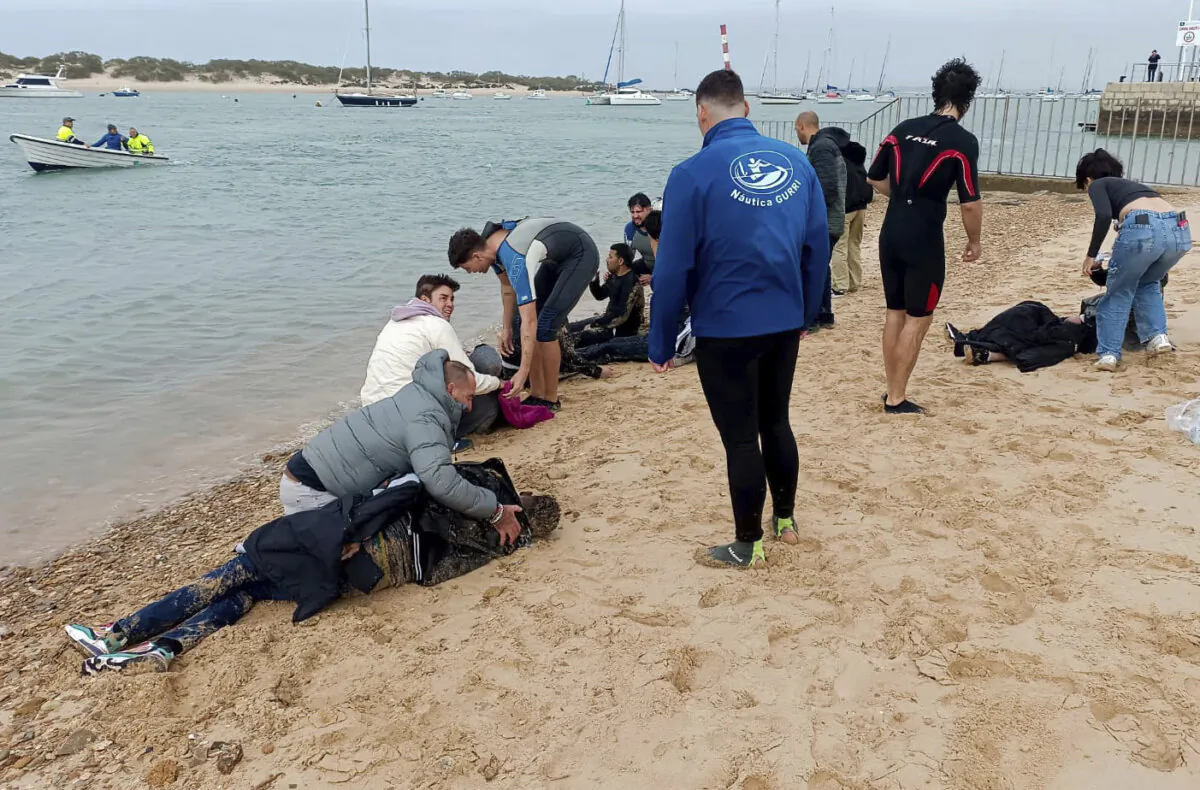 Migrants are rescued by locals on the shore of a beach close to the southwestern city of Cádiz, Spain, on Nov. 30, 2023. (Jorge Gonzalez Casares/AP Photo)