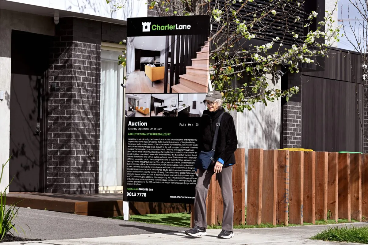 A woman walks past an auction sign outside a house in Melbourne, Australia, on Sept. 5, 2023. (William West/AFP via Getty Images)