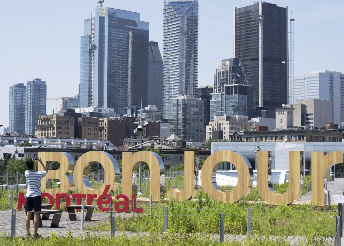 A woman takes a photo of the new Bonjour Montreal in the Old Port in Montreal on July 6, 2023. (The Canadian Press/Ryan Remiorz)