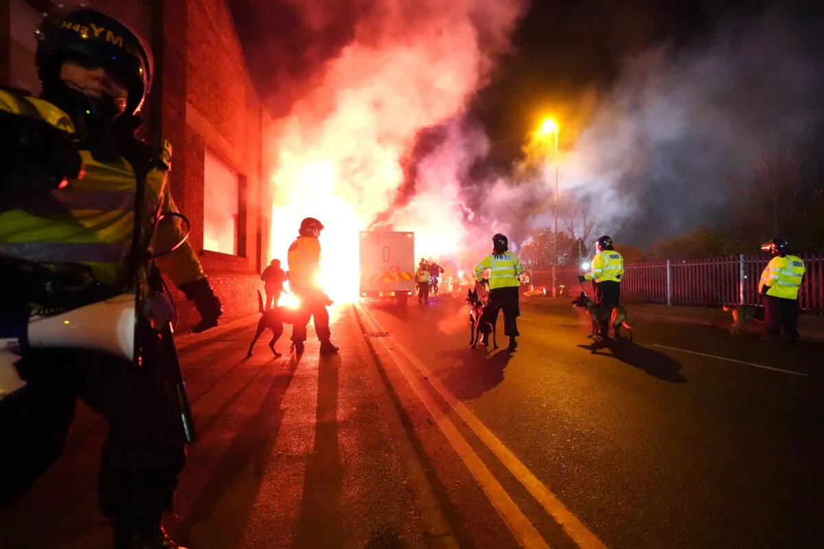 Police officers with dogs as flares are set off outside Villa Park football stadium in Aston, Birmingham, England, on Nov. 31, 2023. (David Davies/PA)
