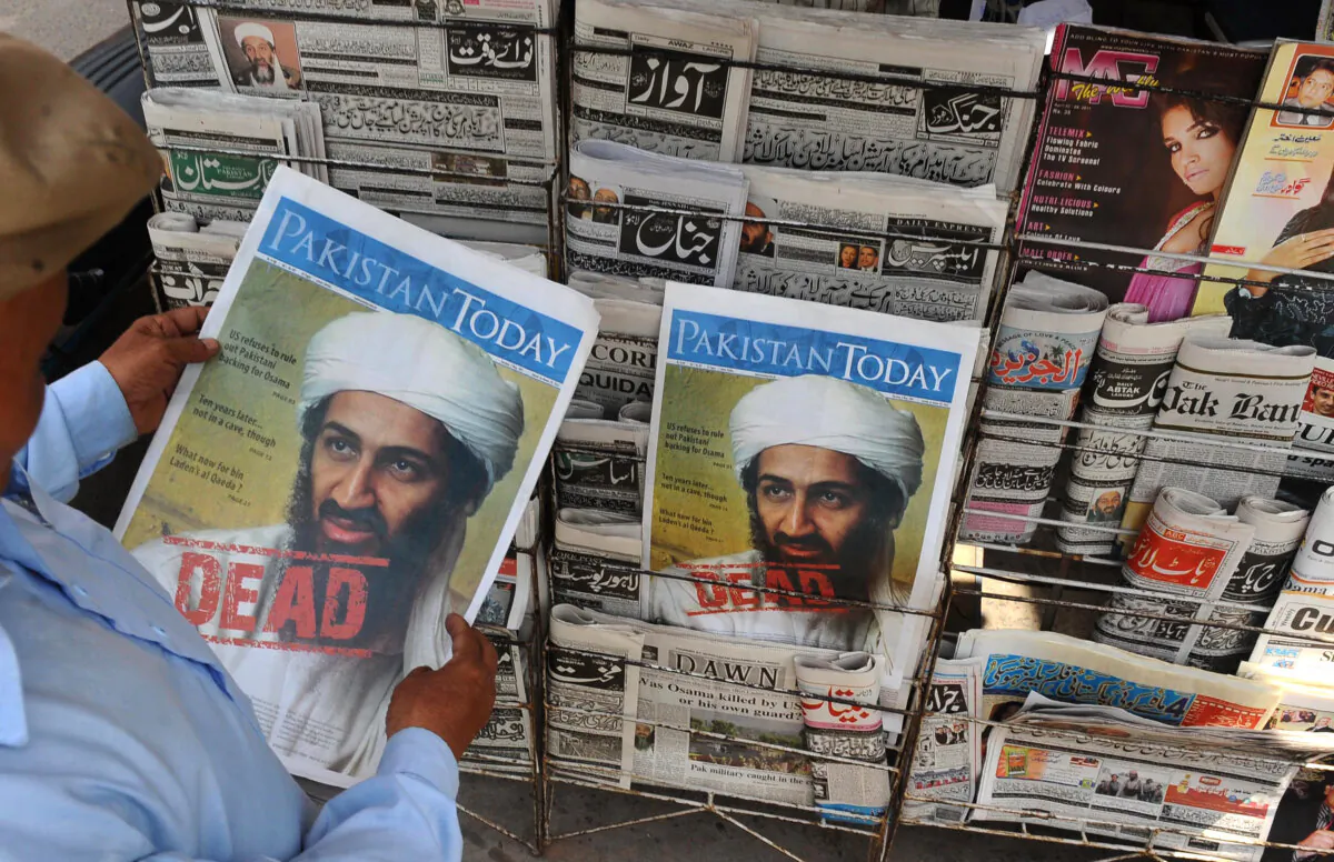 A Pakistani man reads a newspaper with the front page displaying news of the death of Osama bin Laden at a stall in Lahore on May 3, 2011. (Arif Ali/AFP via Getty Images)