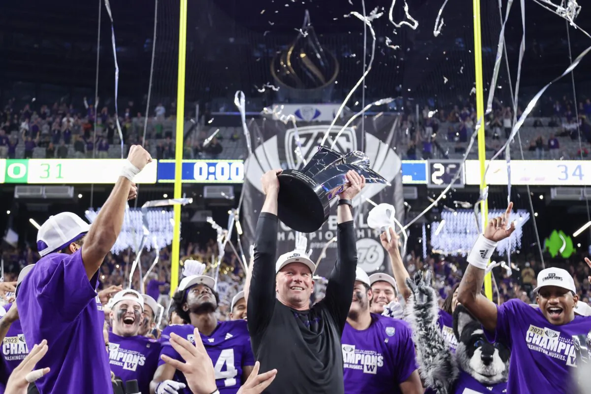Head coach Kalen DeBoer of the Washington Huskies celebrates with his team while lifting the Pac-12 Championship trophy after his team's win against the Oregon Ducks during the Pac-12 Championship in Las Vegas on Dec. 1, 2023. (Ian Maule/Getty Images)