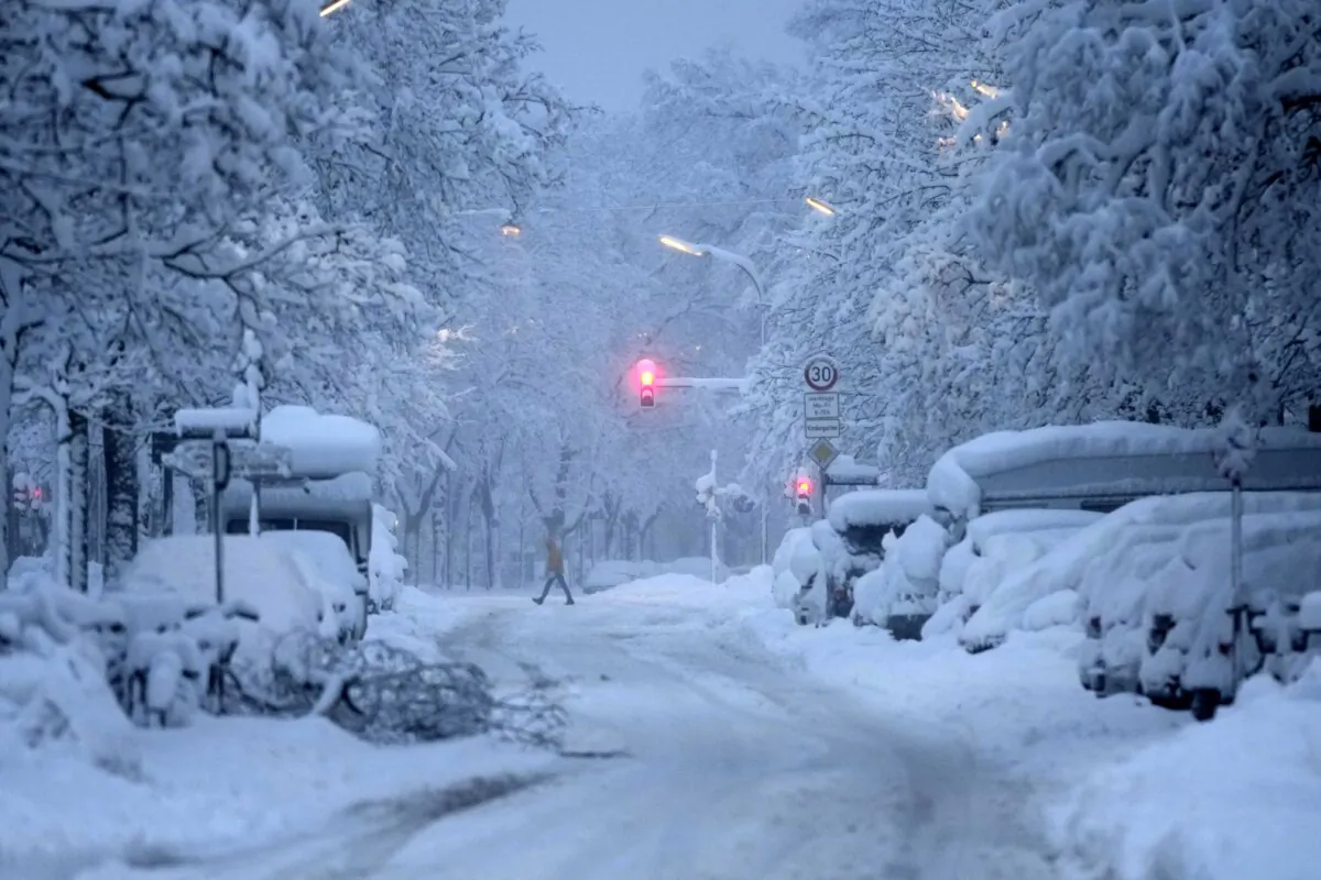 A man crosses a road early morning after heavy snow fall in Munich, Germany, on Dec. 2, 2023. (Matthias Schrader/AP Photo)