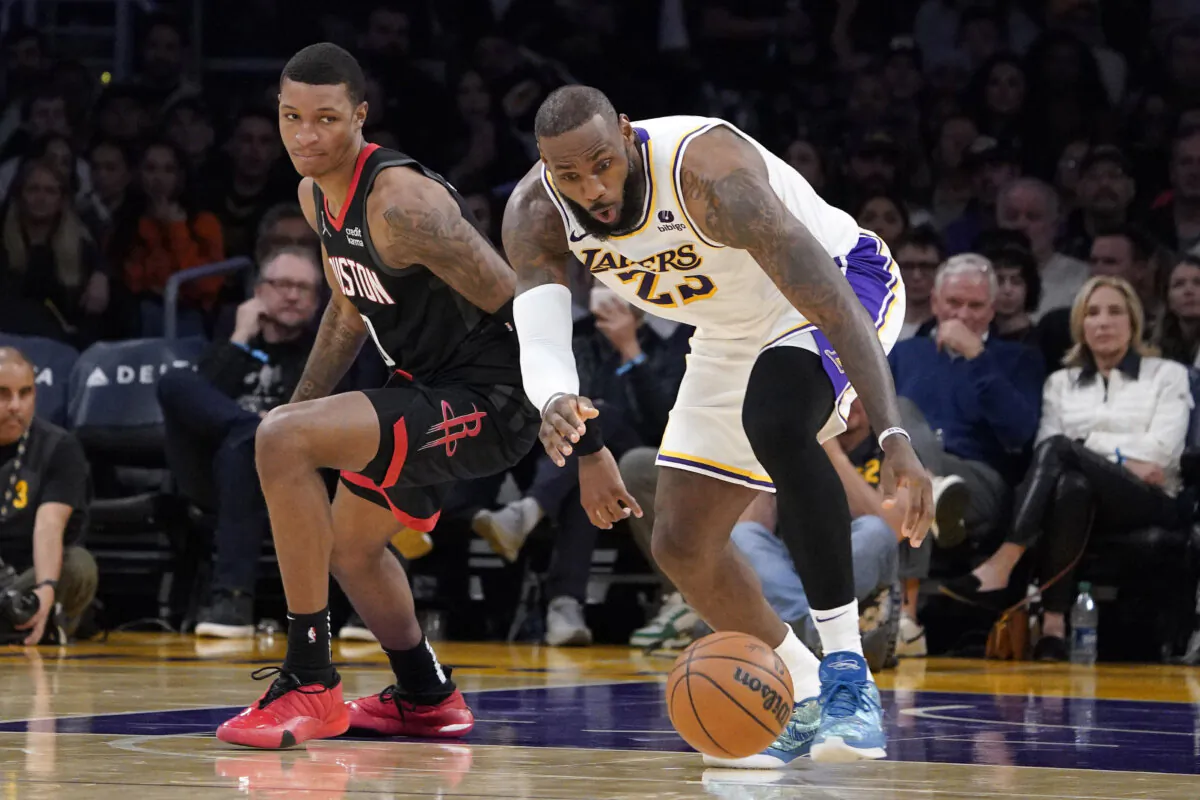Los Angeles Lakers forward LeBron James (R) grabs a loose ball as Houston Rockets forward Jabari Smith Jr. watches during the second half of an NBA basketball game in Los Angeles on Dec. 2, 2023. (Mark J. Terrill/AP Photo)