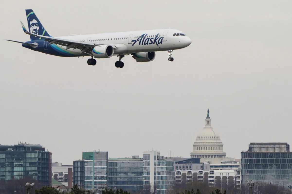An Alaska Airlines aircraft flies past the U.S. Capitol before landing at Reagan National Airport in Arlington, Va., on Jan. 24, 2022. (Joshua Roberts/Reuters)