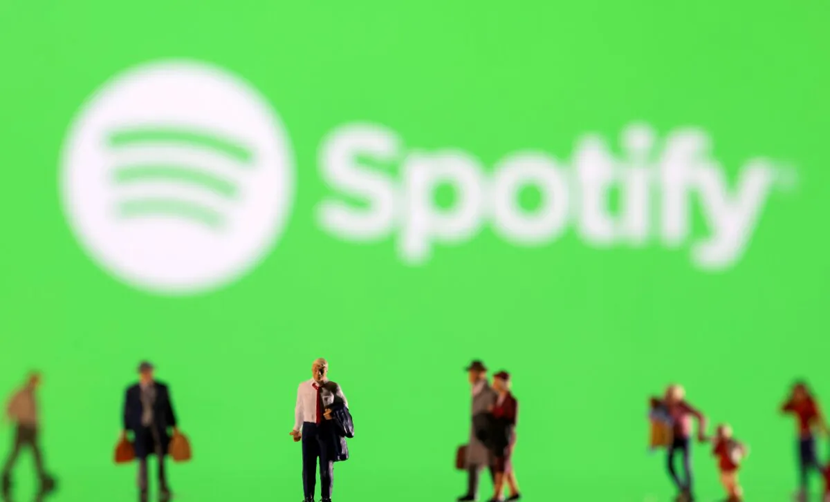 Small figurines in front of Spotify logo in this illustration taken on Feb. 11, 2022. (Dado Ruvic/Ilustration/Reuters)