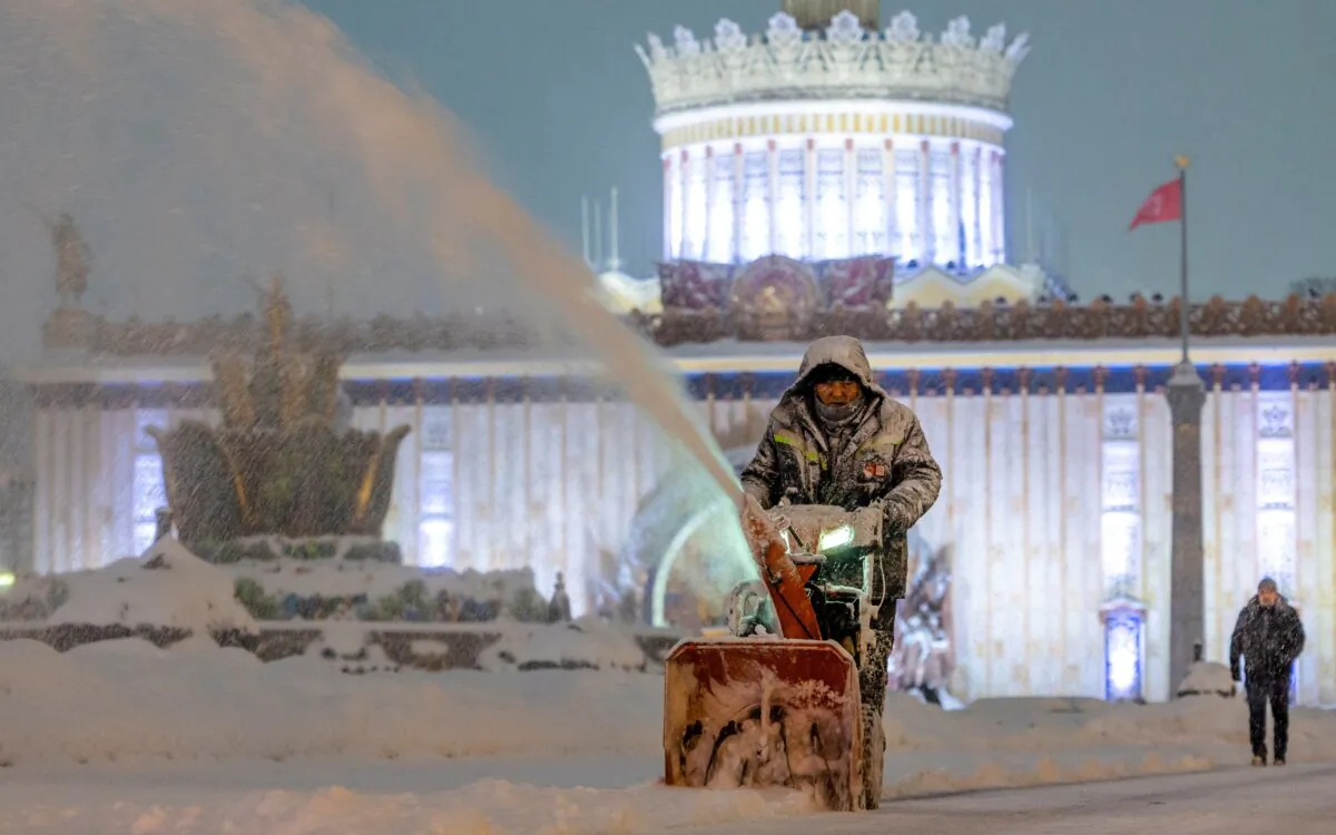 A communal worker cleans snow at the Exhibition of Achievements of National Economy (VDNH) during a heavy snowfall in Moscow on Dec. 3, 2023. (Maxim Shemetov/Reuters)