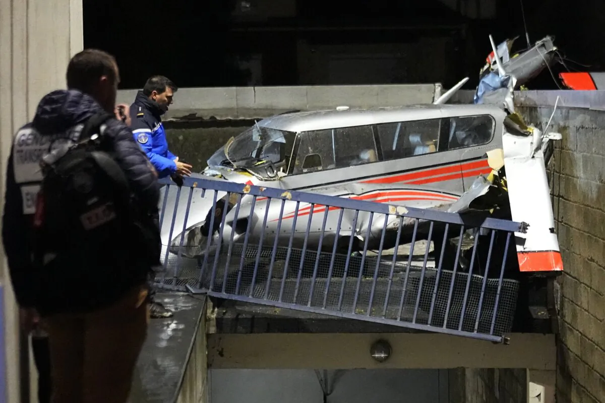 Police officers stand by a small plane that made an emergency landing in a residence in Villejuif, outside Paris, on Dec. 4, 2023. (Michel Euler/AP Photo)