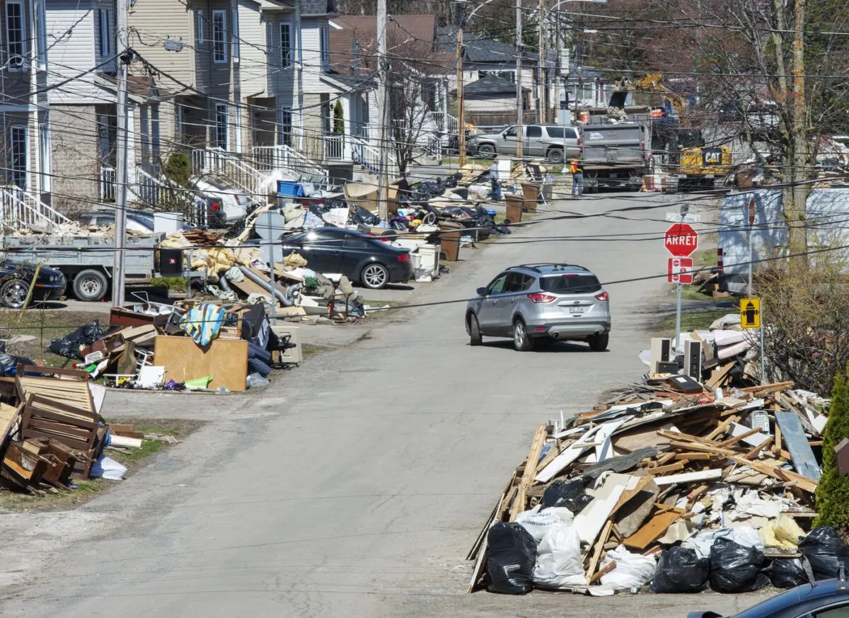 Debris lines a street as clean up continues in parts of Ste.Marthe-sur-la-Lac, Que., on May 6, 2019. (The Canadian Press/Ryan Remiorz)