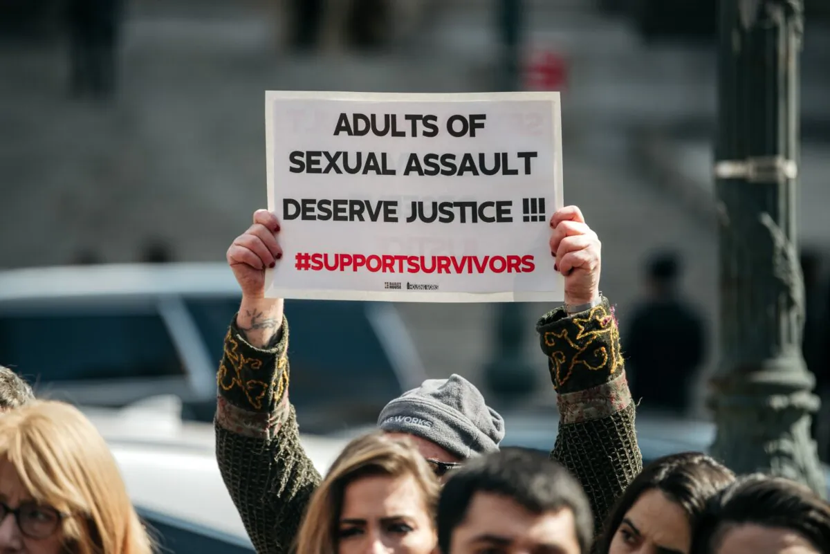 A demonstrator holds a sign overhead at a rally in support of the Adult Survivors Act, in New York City, on Feb. 28, 2020. (Scott Heins/Getty Images)