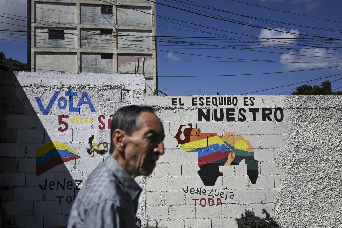A man walks by a mural campaigning for a referendum to ask Venezuelans to consider annexing the Guyana-administered region of Essequibo, in Caracas, Venezuela, on Nov. 28, 2023. (Federico Parra/AFP via Getty Images)