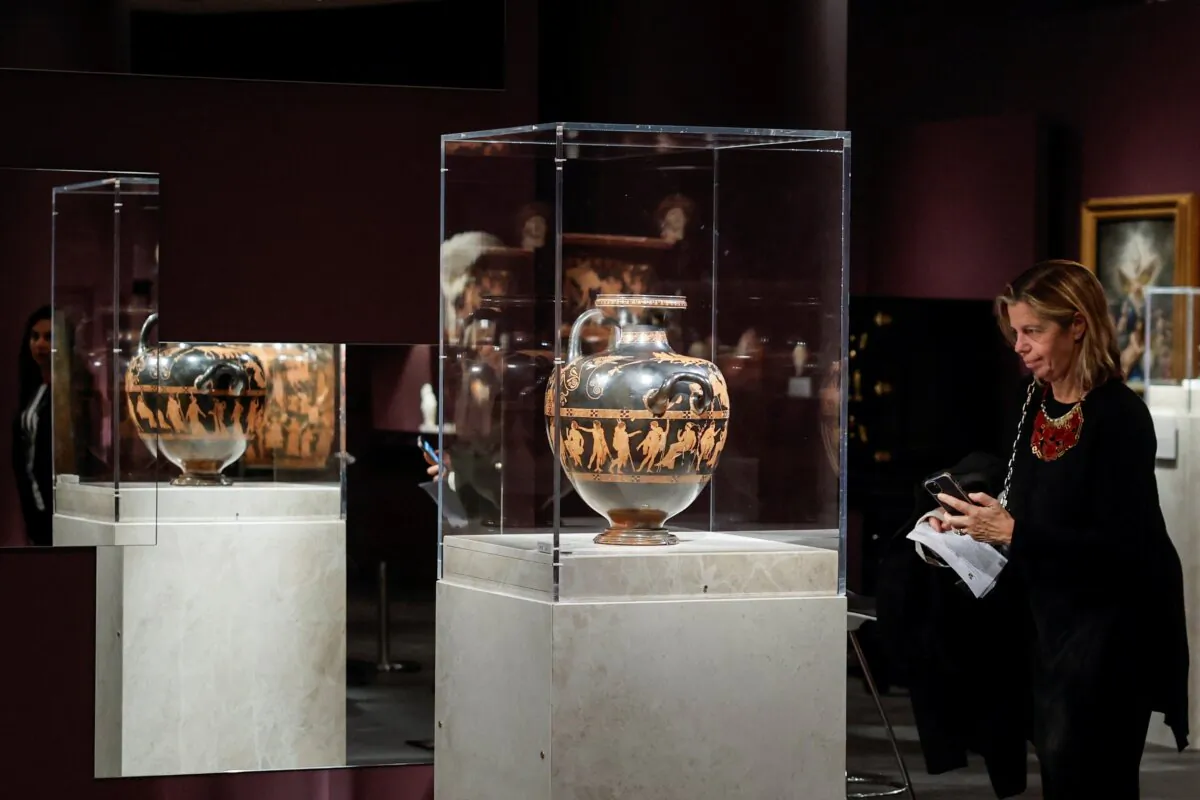 A woman admires the 'Meidias hydria', an Ancient Greek vase from 420 BC, on loan from the British museum for the temporary exhibition titled Meanings' at the Acropolis Museum in Athens, Greece, on Dec. 5, 2023. (Louisa Gouliamaki/Reuters)
