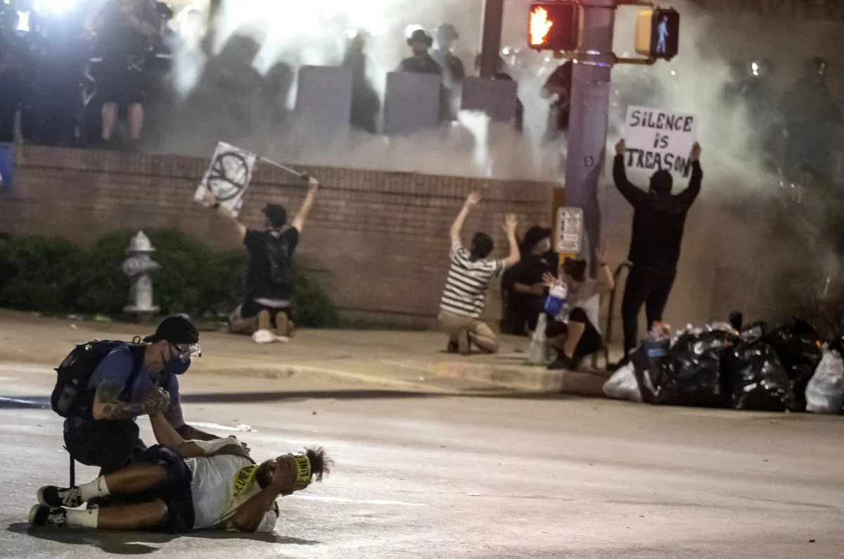 People help a protester after he was shot with a rubber bullet under Interstate 35 freeway in Austin, Texas, on May 30, 2020. (Ricardo B. Brazziell/Austin American-Statesman via AP)