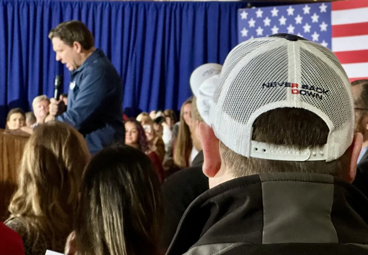 A supporter of Florida Gov. Ron DeSantis' bid for the Republican Party's presidential nomination watches hm speak at a rally in Newton, Iowa, on Saturday, Dec. 2, 2023. (Austin Alonzo/The Epoch Times)