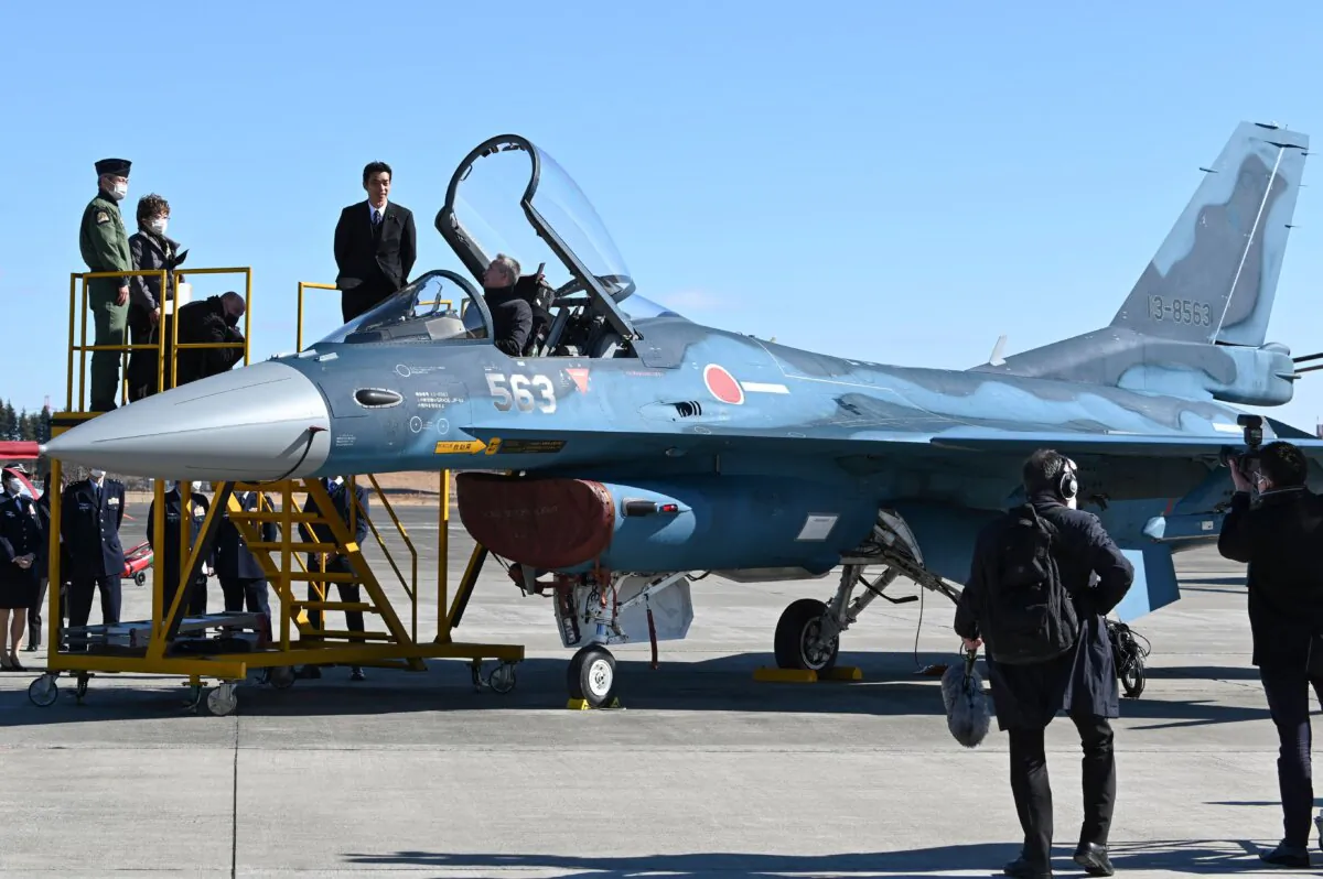 NATO Secretary General Jens Stoltenberg (C) sits in the cockpit of an F-2 fighter plane during an inspection at the Japanese Air Self-Defense Force Iruma Air Base in Sayama, Saitama Prefecture, on Jan. 31, 2023. (Kazuhiro Nogi / AFP via Getty Images)
