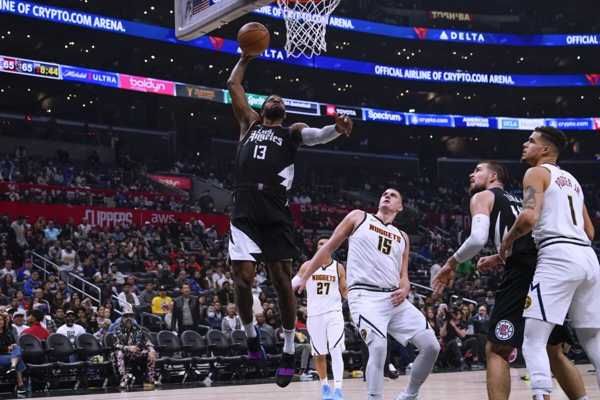 Los Angeles Clippers forward Paul George (13) dunks past Denver Nuggets center Nikola Jokic (15) during the second half of an NBA basketball game in Los Angeles on Dec. 6, 2023. (Ryan Sun/AP Photo)