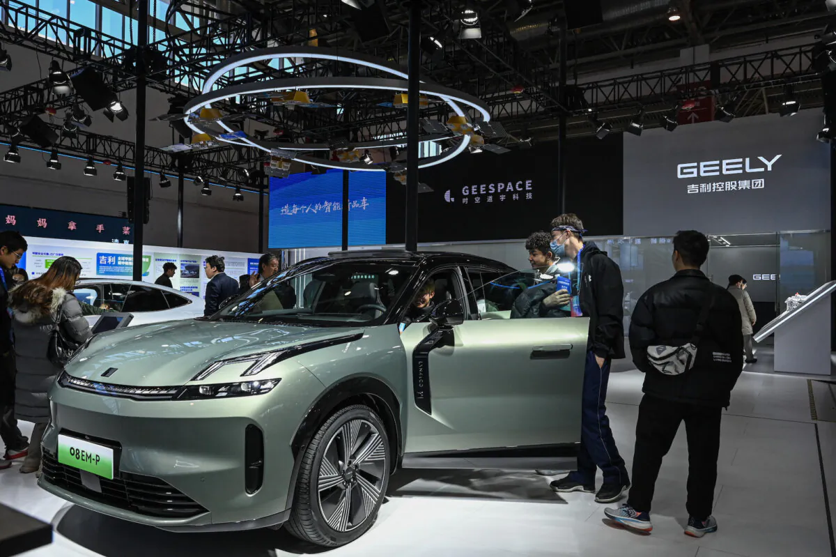 People try an electric vehicle at Geely's booth during the China International Supply Chain Expo in Beijing on Dec. 1, 2023. (Jade Gao/AFP via Getty Images)