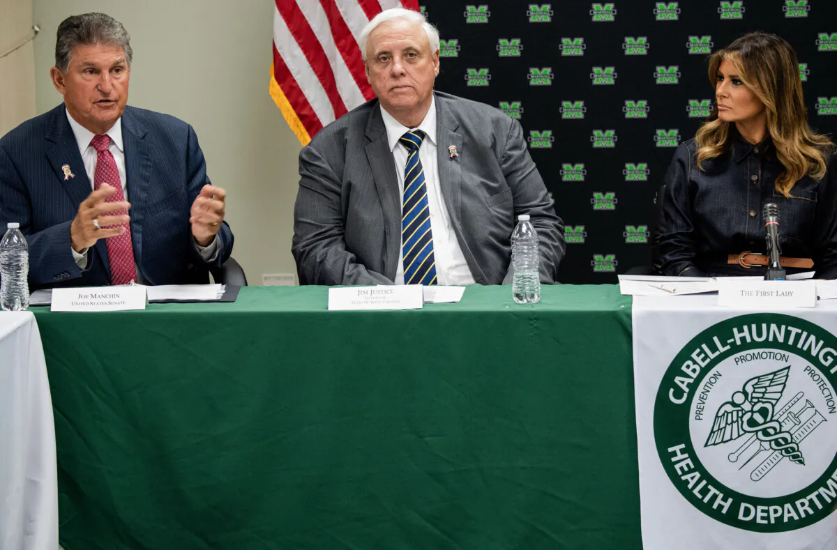 US First Lady Melania Trump (R), West Virginia Governor Jim Justice (C) and US Senator Joe Manchin (L), Democrat of West Virginia, attend a roundtable discussion on the opioid epidemic with local and state officials at the Cabell-Huntington Health Department in Huntington, West Virginia, July 8, 2019. (Photo by SAUL LOEB / AFP) (Photo credit should read SAUL LOEB/AFP via Getty Images)