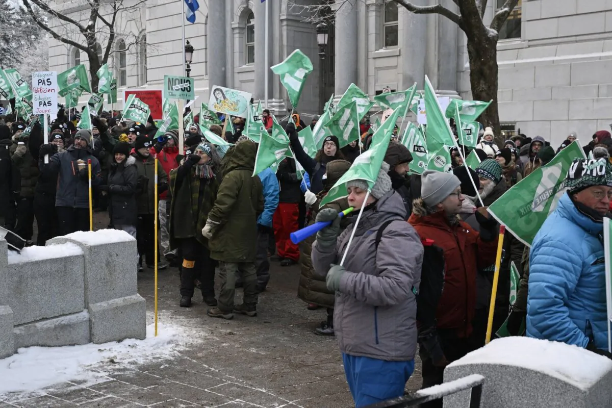 Common front union members demonstrate, blocking the entrance of the National Assembly at the legislature in Quebec City on Dec. 8, 2023. (The Canadian Press/Jacques Boissinot)