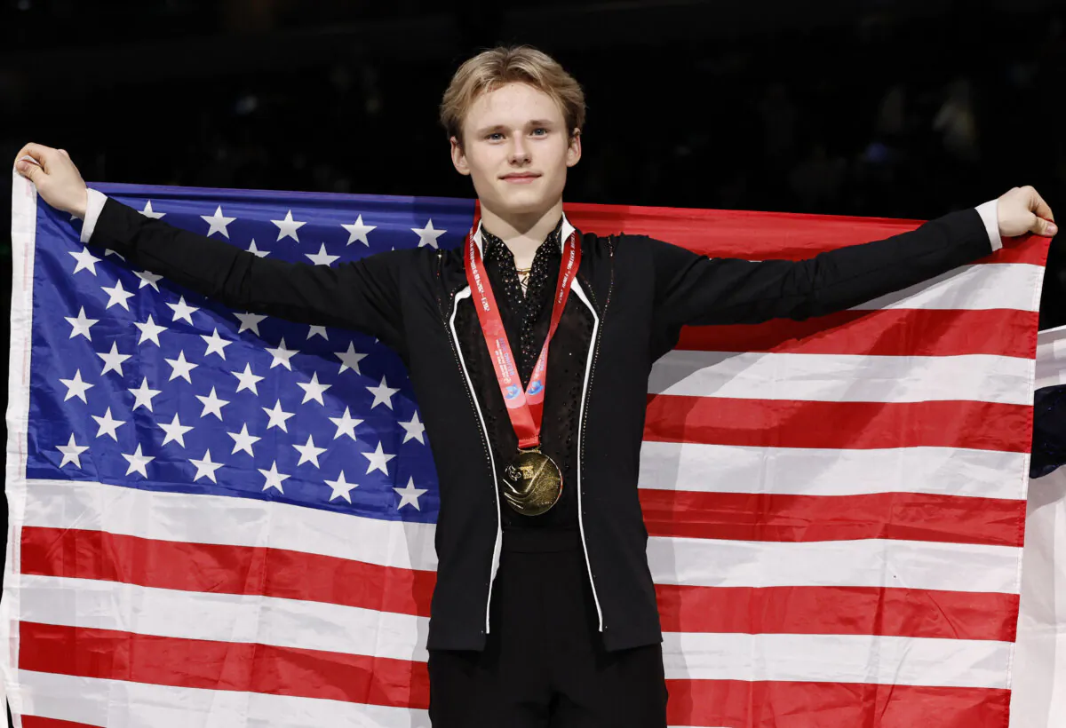 Gold medallist Ilia Malinin of the United States poses with the country's national flag at the medal ceremony for men's free skating event during the ISU Grand Prix of Figure Skating Final in Beijing on Dec. 9, 2023. (Tingshu Wang/Reuters)