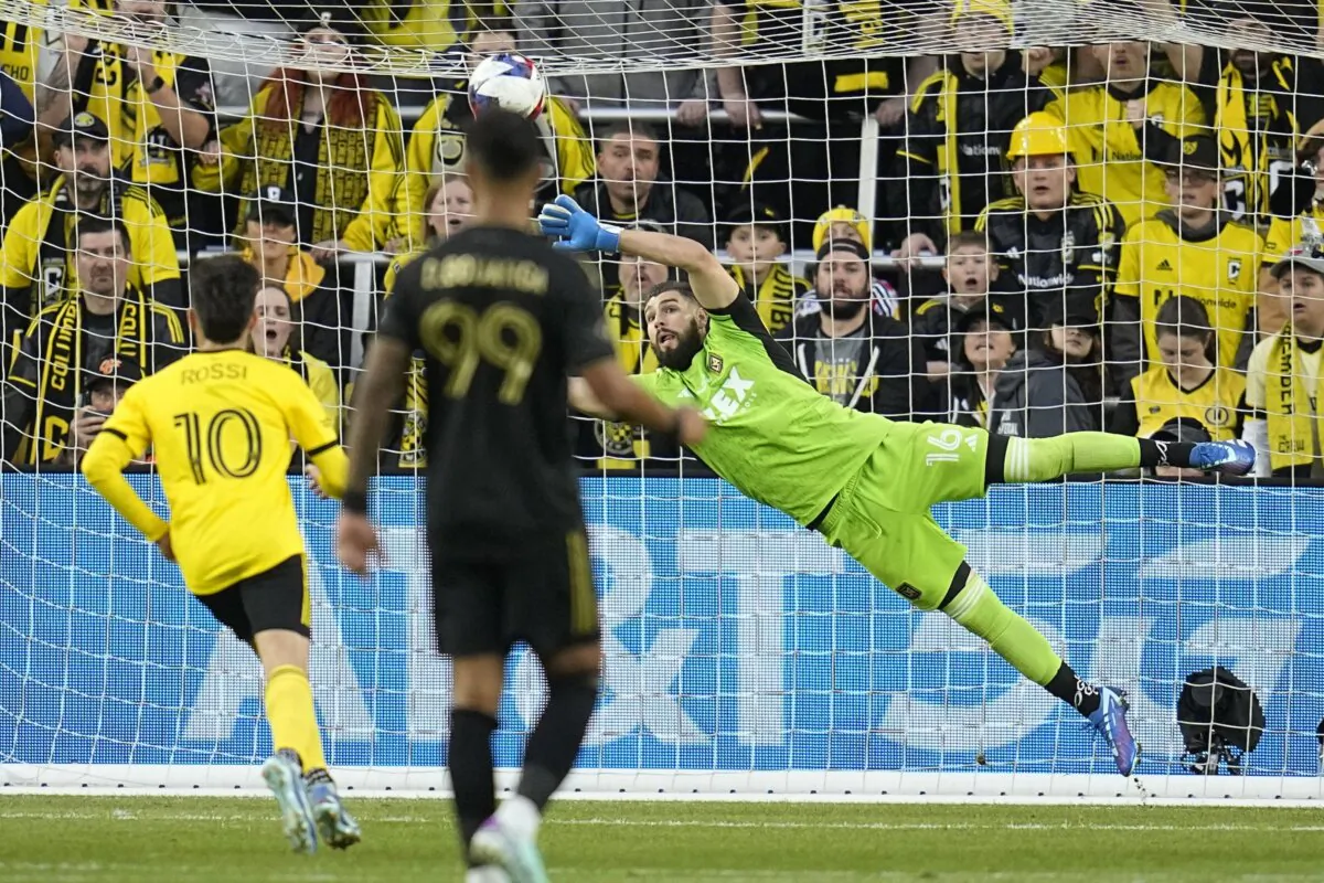 Los Angeles FC goaltender Maxime Crepeau (16) blocks a shot in front of Columbus Crew forward Diego Rossi (10) and LA Galaxy's Denis Bouanga (99) in the first half MLS soccer championship match, in Columbus, Ohio on Dec. 9, 2023. (Sue Ogrocki/AP Photo)