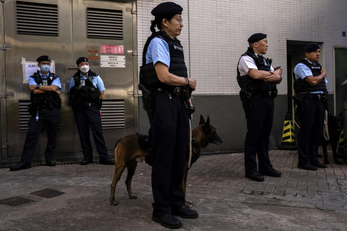 Police officers patrol outside a polling station during the District Council elections in Hong Kong on Dec. 10, 2023. (Louise Delmotte/AP Photo)