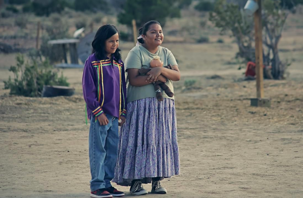 boy and girl stand in field in FRYBREAD FACE AND ME