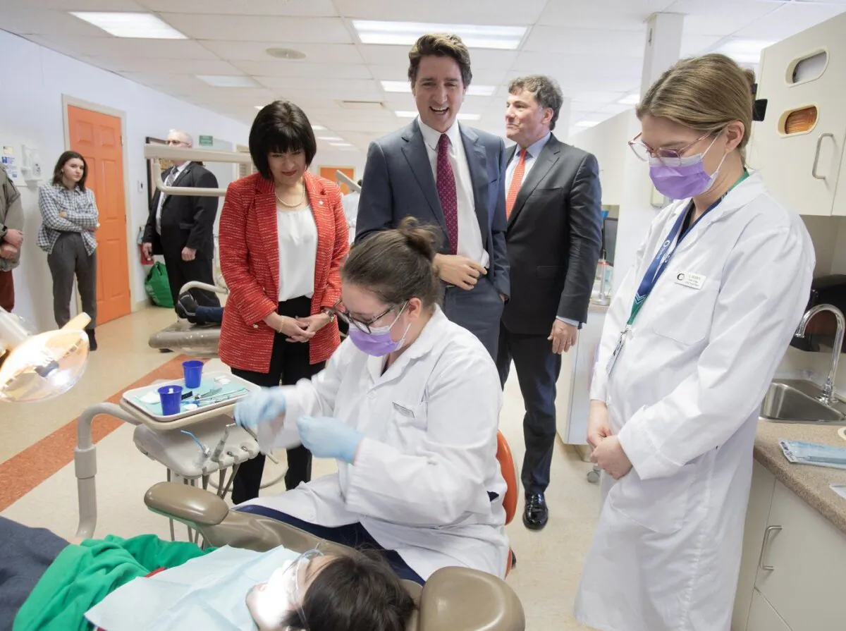 Prime Minister Justin Trudeau (C) and ministers Dominic LeBlanc and Ginette Petitpas Taylor speak with dental hygienist students and patients at Oulton College in Moncton, N.B., on March 31, 2023. (The Canadian Press/Ron Ward)