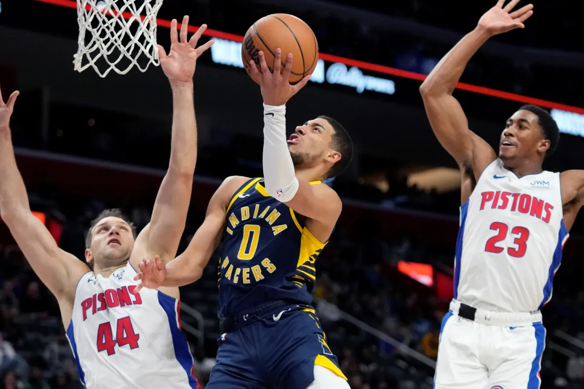 Indiana Pacers guard Tyrese Haliburton (0) attempts a layup as Detroit Pistons forward Bojan Bogdanovic (44) and guard Jaden Ivey (23) defend during the first half of an NBA basketball game in Detroit on Dec. 11, 2023. (Carlos Osorio/ AP Photo)