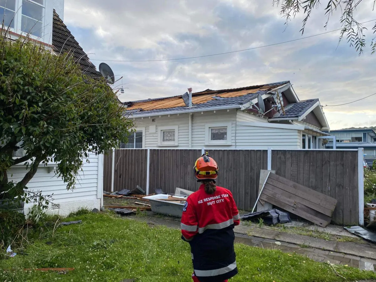 A member of NZ Response Team 18 (NZRT-18) outside one of the homes damaged by a 'tornado' which struck the Hutt Valley (Courtesy of NZRT-18 / Hutt City Council)