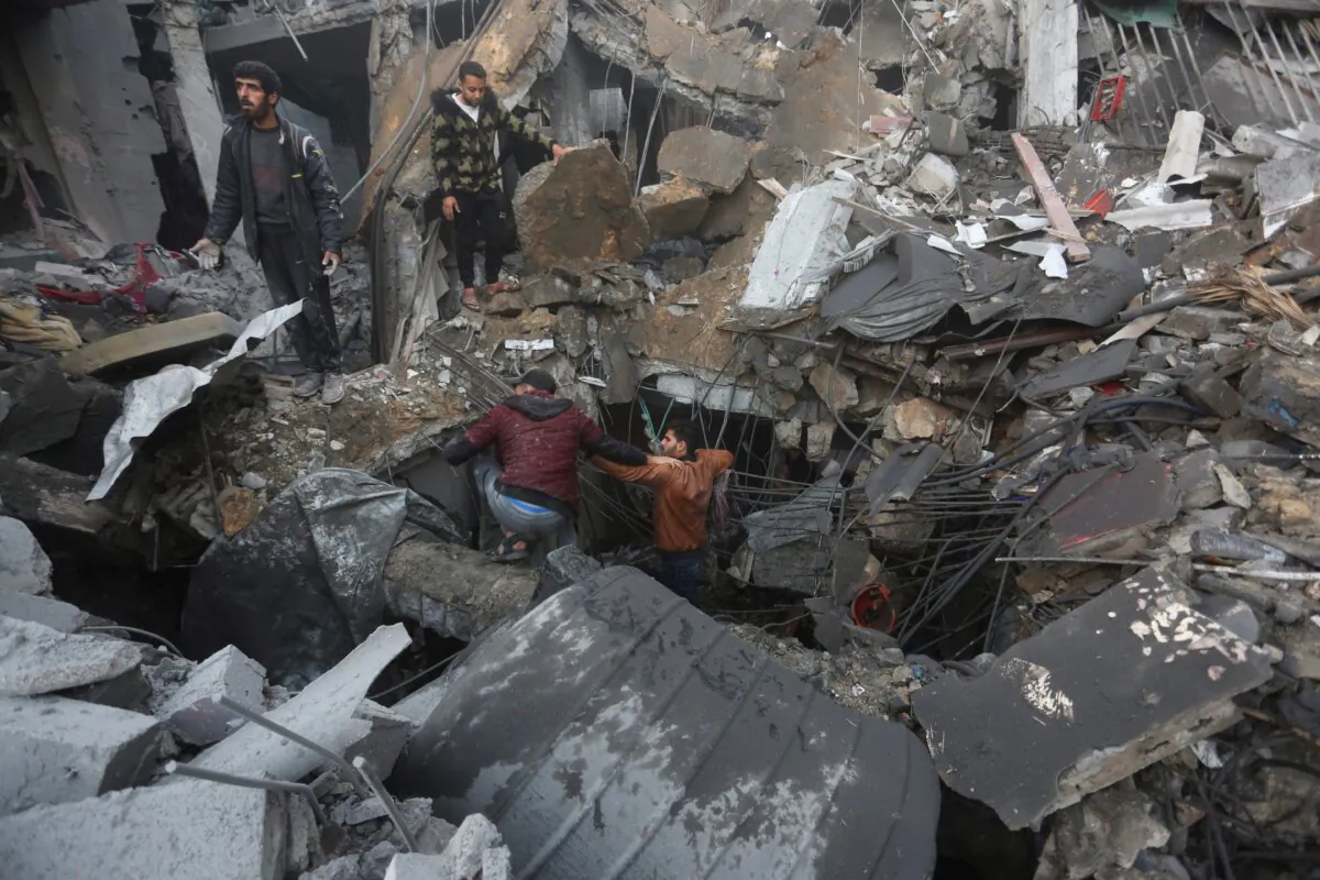 Palestinians look for survivors of the Israeli bombardment of the Gaza Strip in Rafah on Dec. 12, 2023. (Hatem Ali/AP Photo)