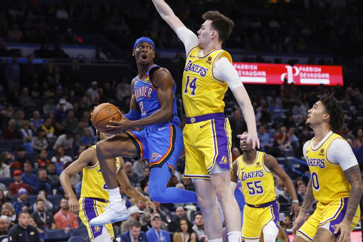 Oklahoma City Thunder guard Shai Gilgeous-Alexander (2) prepares to pass the ball away from Los Angeles Lakers center Colin Castleton (14) as Lakers guard Jalen Hood-Schifino (R) watches during the second half of an NBA basketball game in Oklahoma City on Nov. 30, 2023. (Nate Billings/AP Photo)